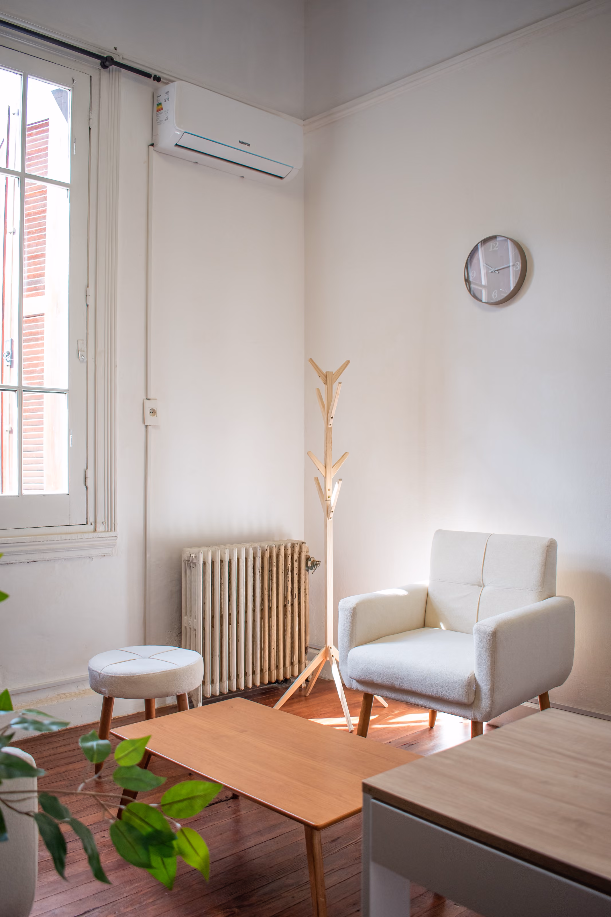 Consultorio 01: el sillón de atención junto al radiador y el perchero, con el aire acondicionado sobre la ventana.