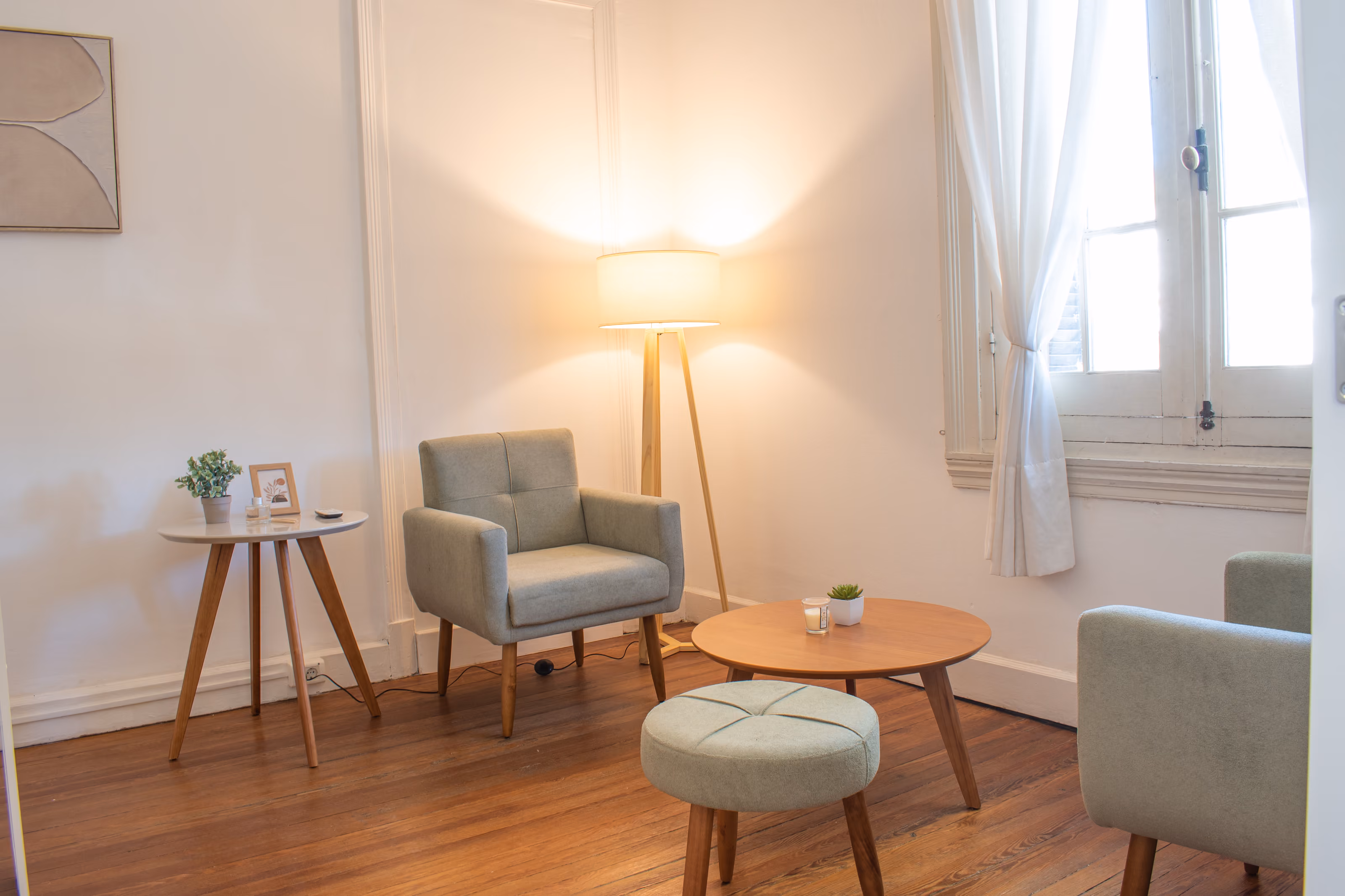 Consultorio 03: los dos sillones en ángulo alrededor de la mesa baja, con la lámpara de pie encendida.