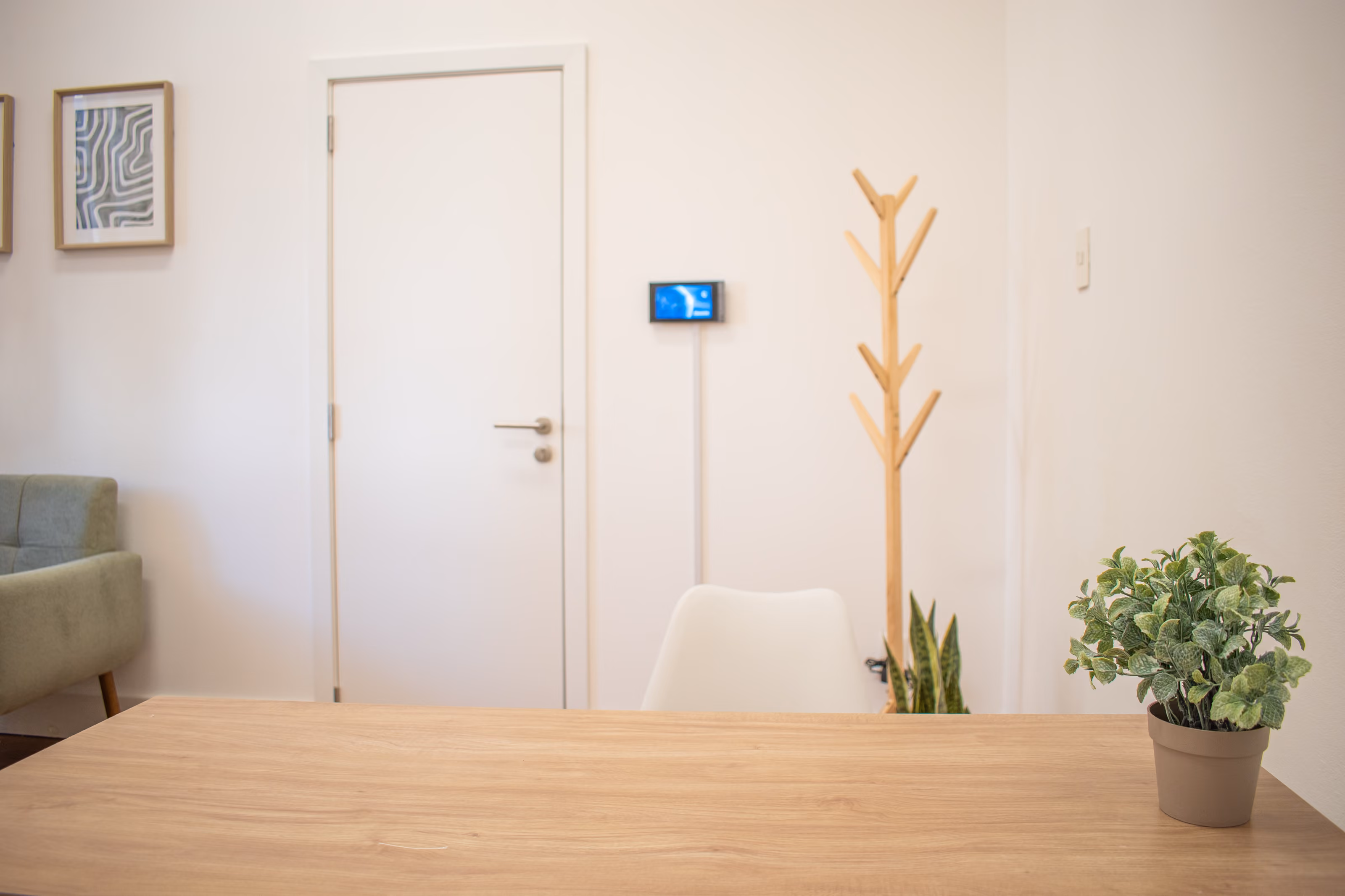 Pantalla de portería montada en la pared de un consultorio, junto a la puerta.